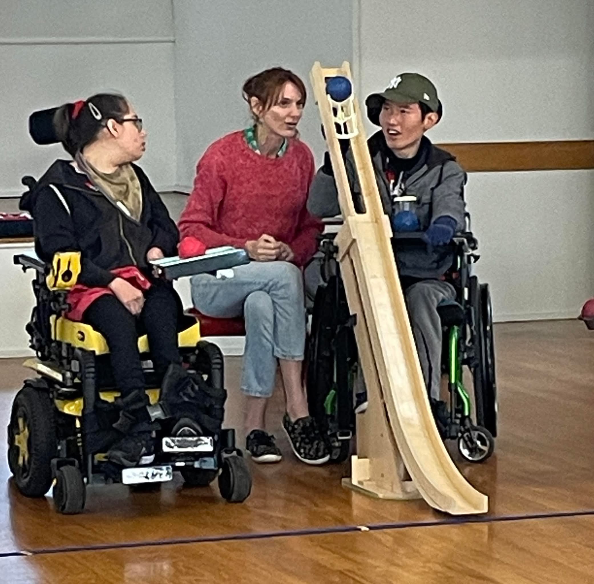 A blue boccia ball at the top of a wooden ramp
